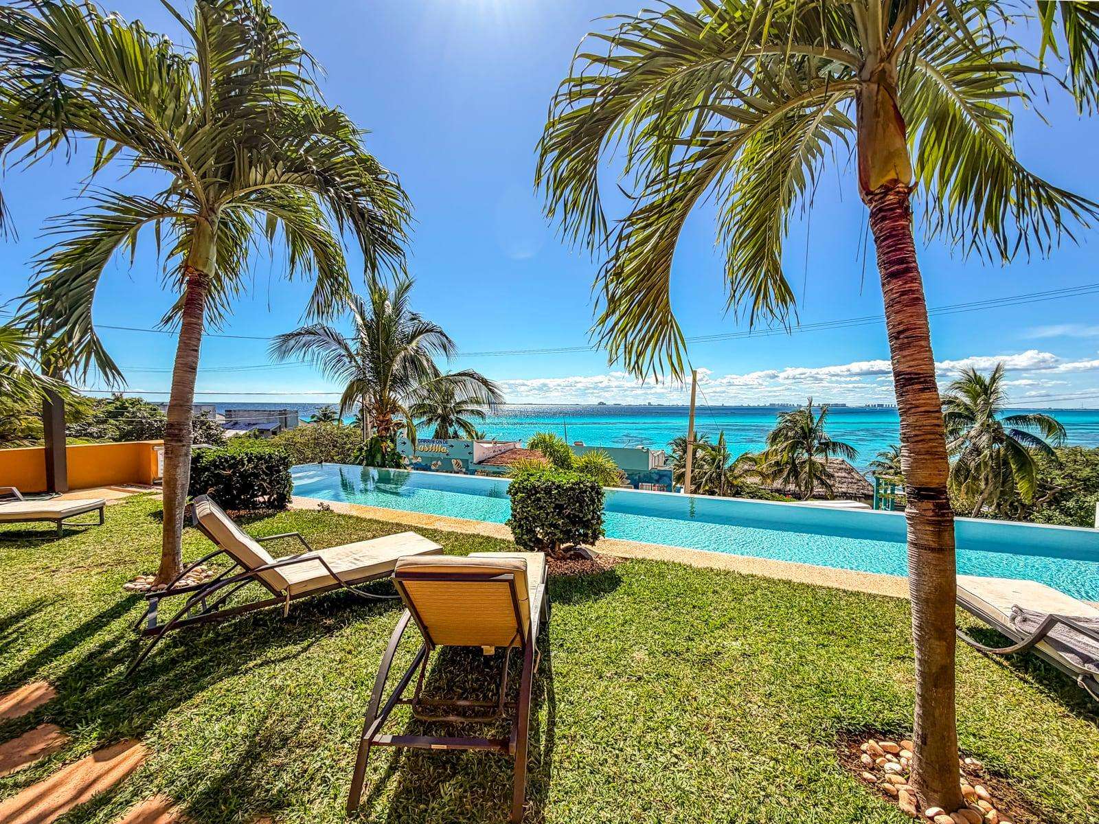 Infinity pool with palm trees and ocean views at Sotavento
